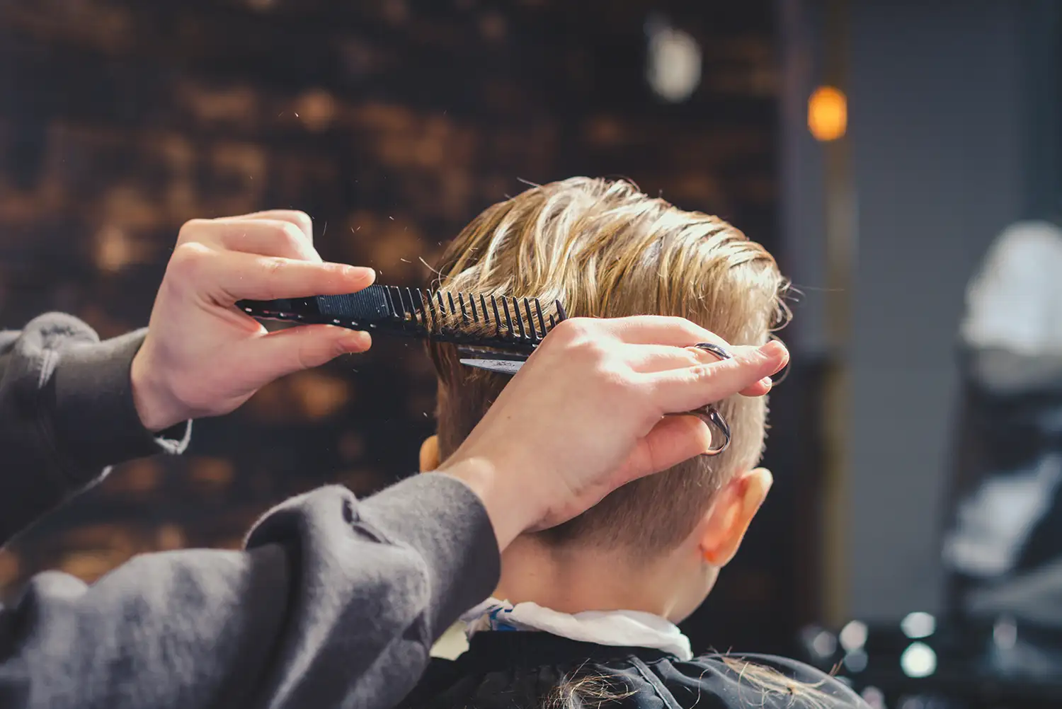 Kleiner Junge bekommt Haarschnitt von Barbier